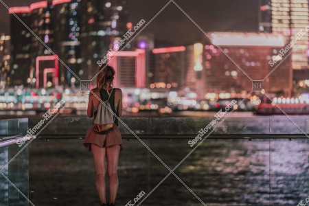 夜のヴィクトリア・ハーバーと女性