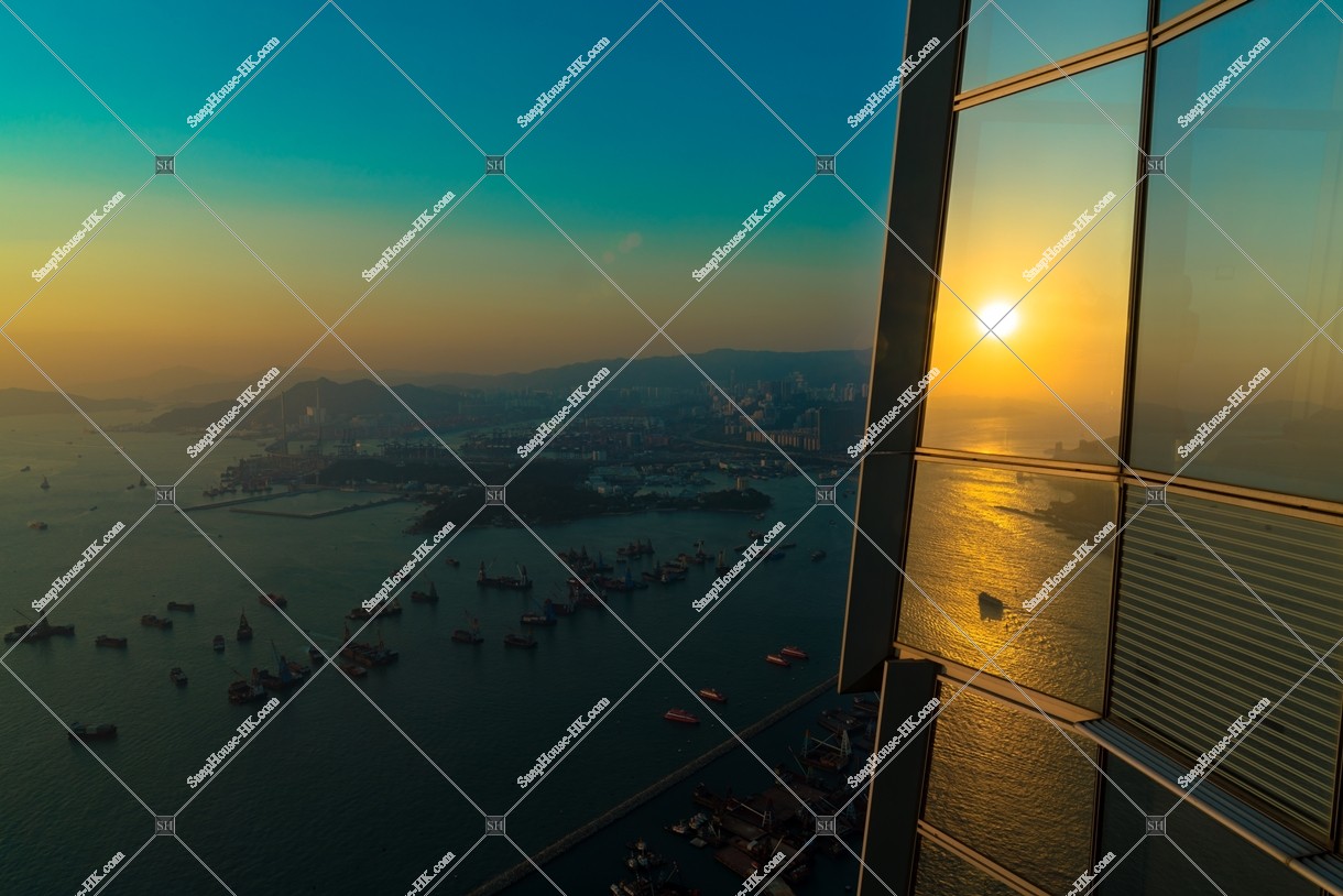 The sunset reflected on the window of SKY 100 and the view of the west side of Hong Kong