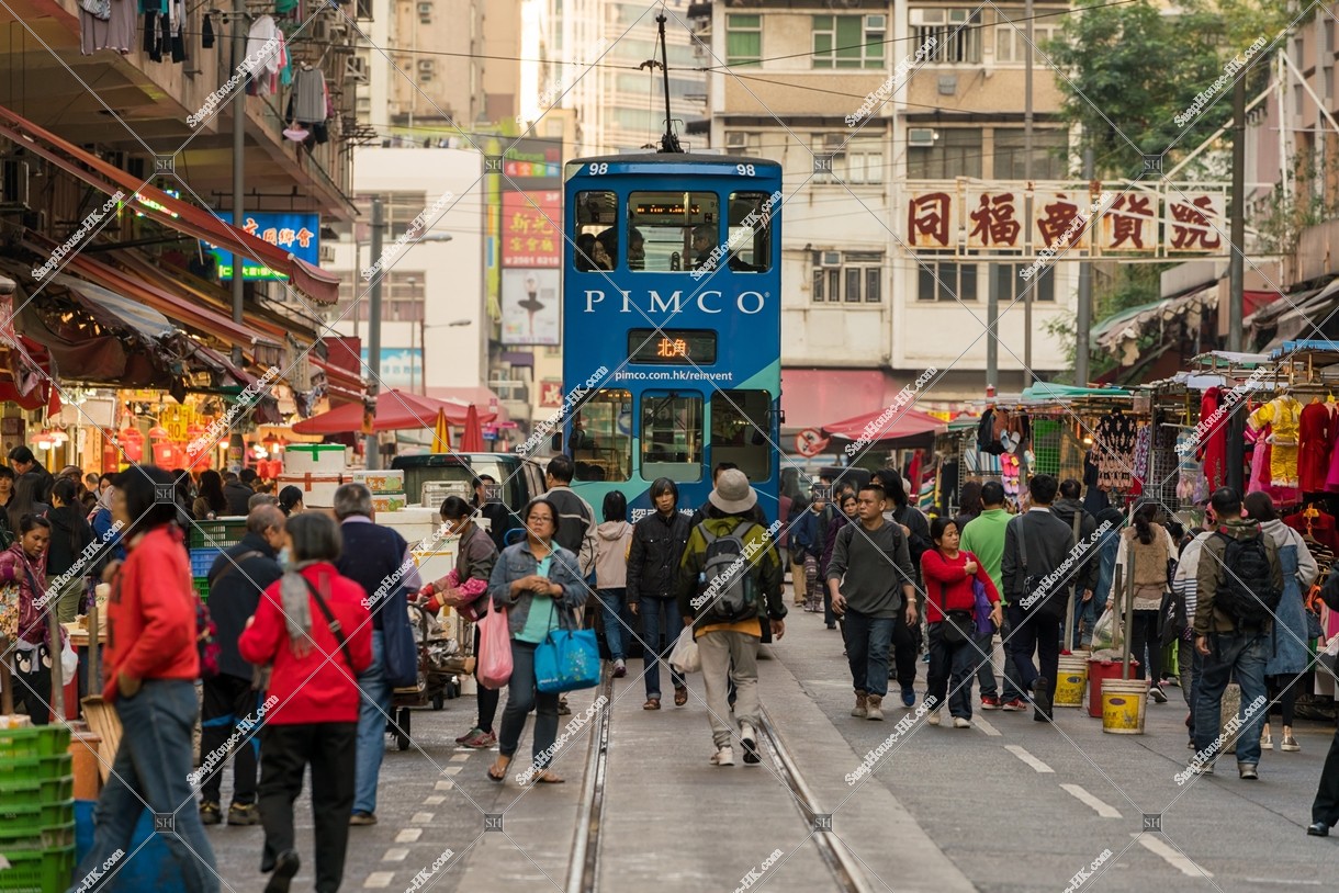 People walking in shopping street of Chun Yeung Streetand Hong Kong Tramway [Portrait]