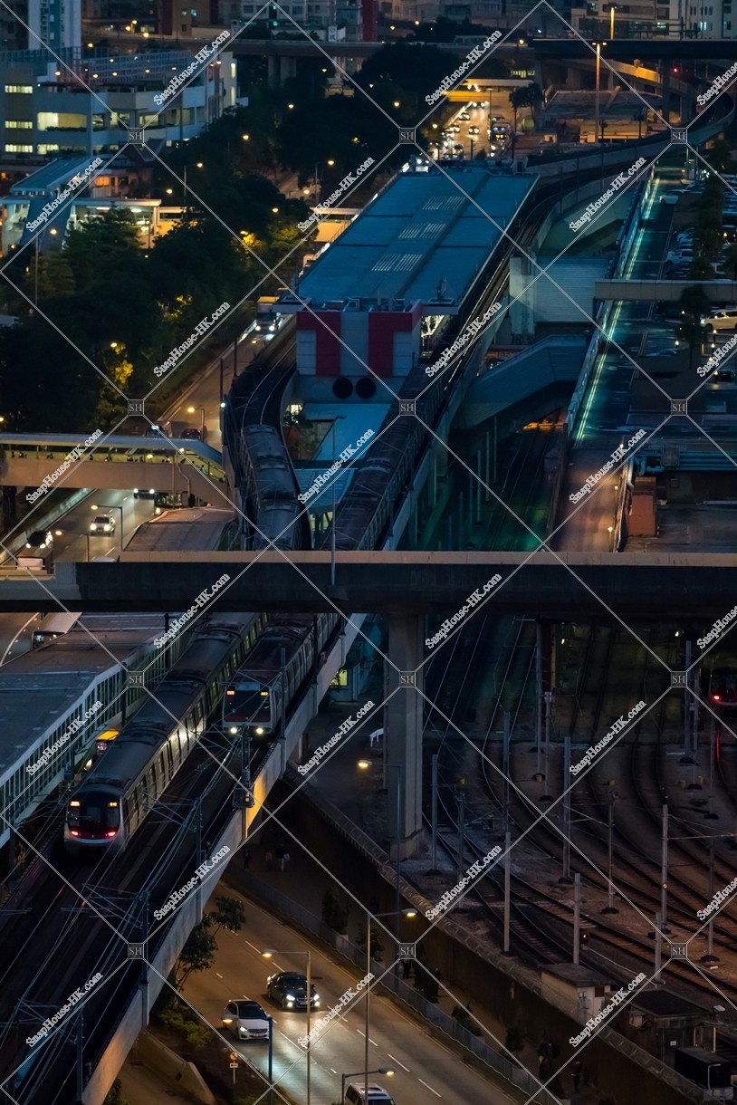 MTR train departing and arriving at Kowloon Bay Station after the sunset