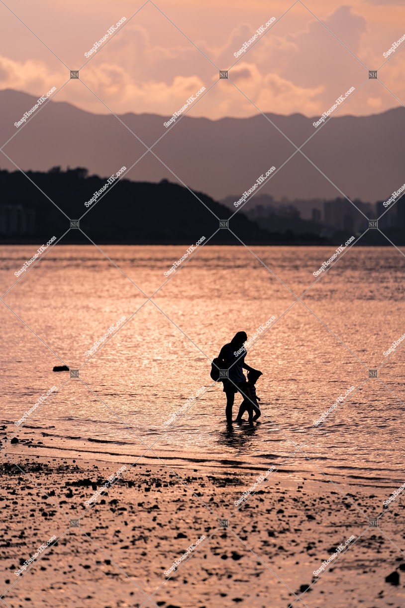 Evening view of Wu Kai Sha Beach with parent and child