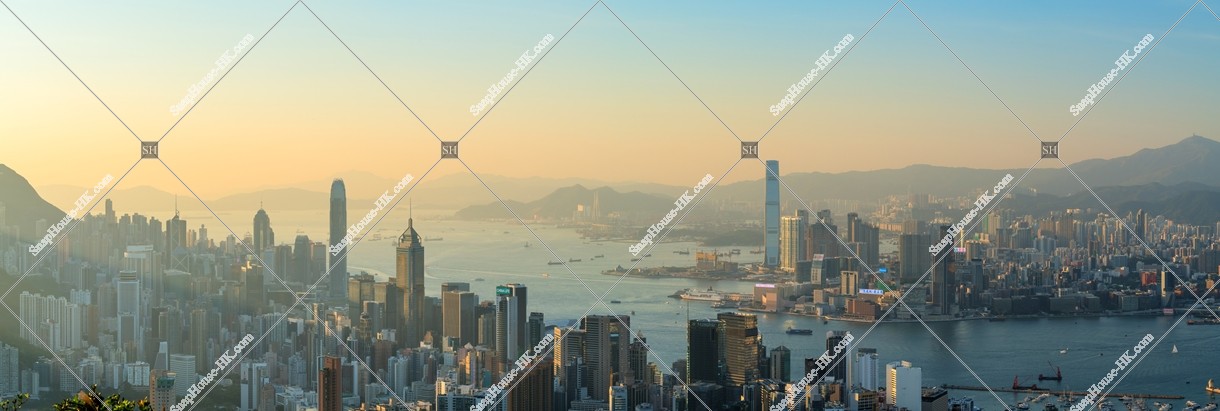 Panoramatic skyline view of Hong Kong Island and Kowloon Peninsula in the evening