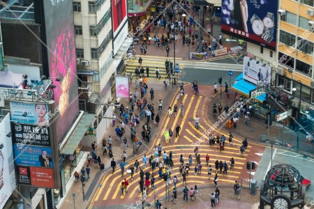 Walkway and crowd of people cross the street in front of Times Square [Portrait]