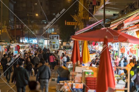 Hong Kong Tramway coming along with the crowded people in the Spring Street at night
