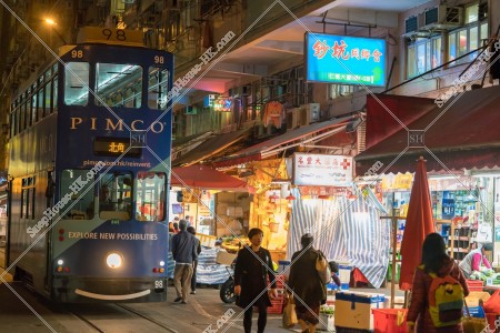 Hong Kong Tramway driving to shopping street of Spring Street at night