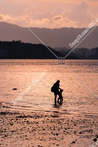 Evening view of Wu Kai Sha Beach with parent and child