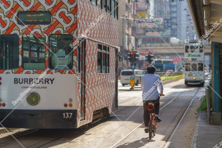 Hong Kong Tramway traveling through Causeway Bay with a bicycle
