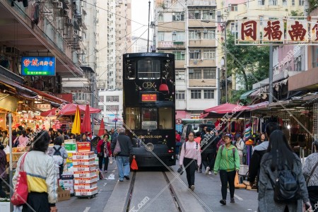 在春秧街的露天街行駛中的香港電車(叮叮)和購物中的人們